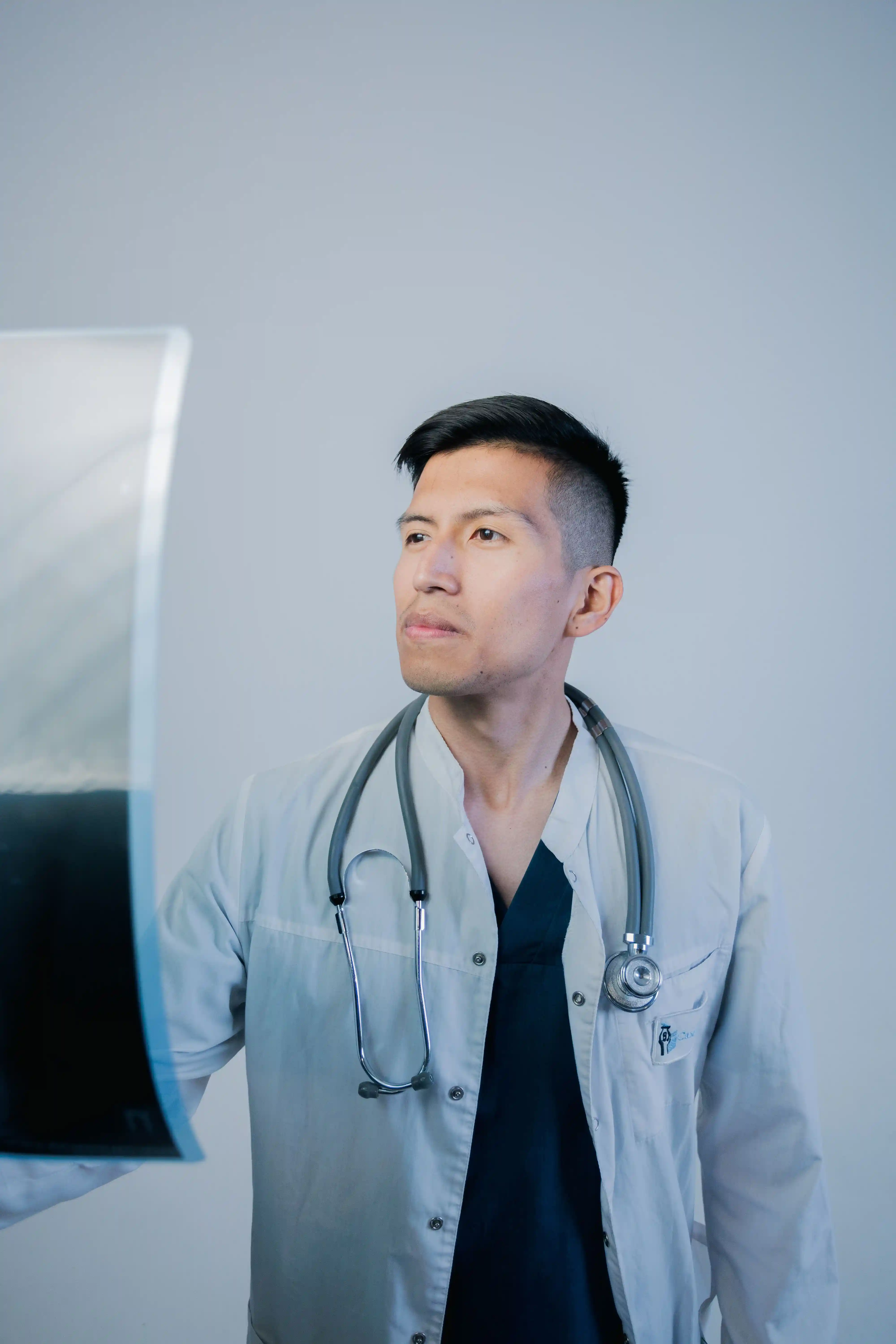 Doctor with a stethoscope studying an X-ray film